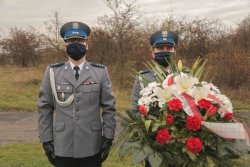 Dwóch policjantów przed pomnikiem na Krzemionkach z wieńcem
