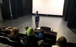 policjantka ruchu drogowego w sali kinowej przekazuje młodzieży zasady bezpieczeństwa w ruchu drogowym
