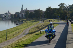 policjant na motocyklu w tle Wawel
