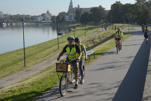 rowerzyści na bulwarach wiślanych w tle Wawel