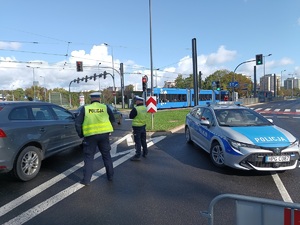 dwóch umundurowanych policjantów kierujących ruchem na jednym ze skrzyżowań na terenie Krakowa