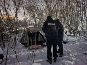 policjanci sprawdzają namiot w którym może przebywać osoba bezdomna