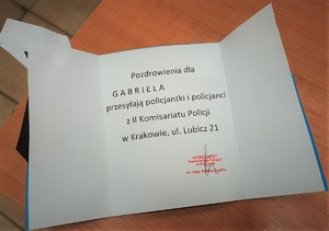Kartka z pozdrowieniami od policjantów Komisariatu wraz z pieczęcią i podpisem Komendanta