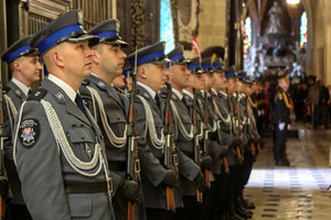 Policjanci kompanii honorowej stojący w szeregu w nawie bocznej kościoła