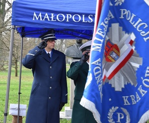 Zastępca Komendanta Miejskiego Policji w Krakowie stojący przed policyjnym sztandarem