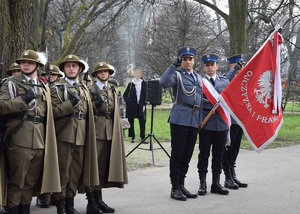 policjanci krakowskiej komendy miejskiej stojący z policyjnym sztandarem