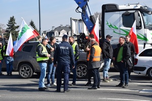 Funkcjonariusz policji rozmawia ze strajkującymi rolnikami