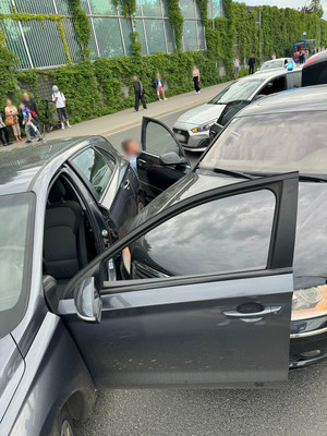 Nieoznakowane policyjne radiowozy oraz zatrzymany po pościgu samochód. W oddali widać osoby na przystanku