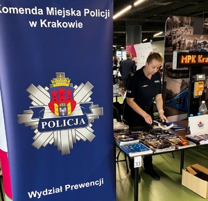 policjantka przy stoisku wystawowym podczas targów pracy