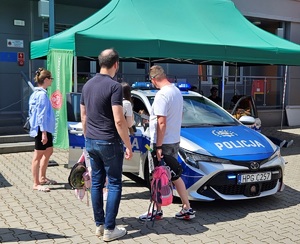 uczestnicy pikniku oglądający policyjny radiowóz