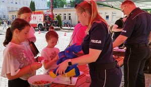 dzieci stojące przy policyjnym stoisku profilaktycznym