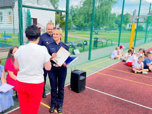 policjantka wręczająca nauczycielce dyplom dla szkoły