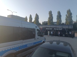 autokar i policjanci zabezpieczający przejazd