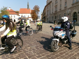 policjant na motocyklu zabezpieczający przejazd rowerzystów