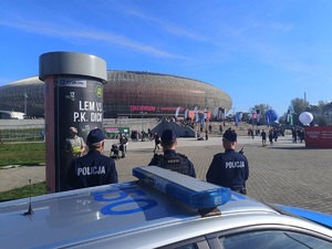 3 policjanci zabezpieczający imprezę sportową przy budynku Tauron Areny