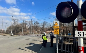 policjantki rozmawiające z pieszym przy przejeździe kolejowym