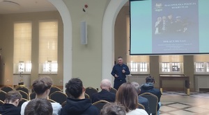 policjant prowadzi prelekcję dla uczniów w oddziale banku