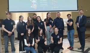 wspólne zdjęcie policjanta i pracowników banku z uczniami