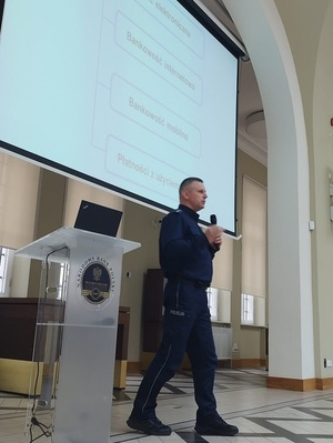 policjant omawia temat bezpieczeństwa usług finansowych