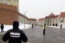 2 Policjanci zabezpieczający wjazd na wzgórze wawelskie. W tle funkcjonariusz SOP.