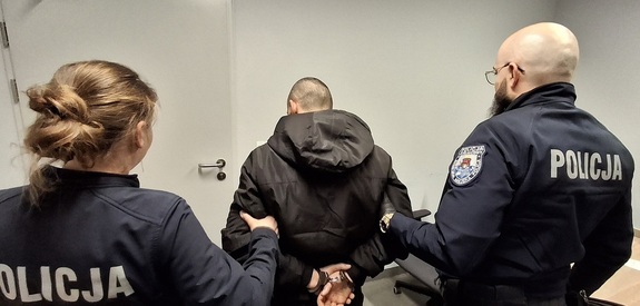 policjanci prowadzą zatrzymanego