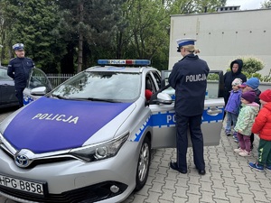 dzieci w towarzystwie policjantów oglądają radiowóz