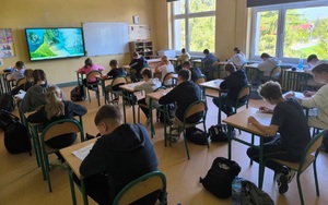 uczniowie piszący test wiedzy w klasie szkolnej