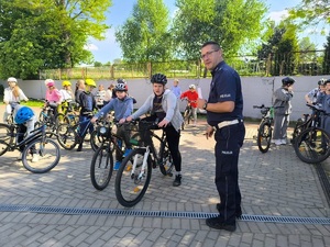 policjant i uczniowie na rowerach podczas egzaminu na kartę rowerową