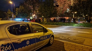 oznakowany radiowóz w porze nocnej zaparkowany nieopodal Uniwersytetu Ekonomicznego w Krakowie
