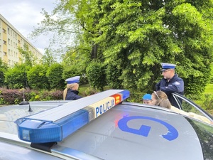 policjanci pokazują i omawiają wyposażenie radiowozu