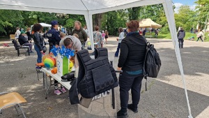 policyjne stoisko profilaktyczny przy którym znajduje się policjant i uczestnicy pikniku