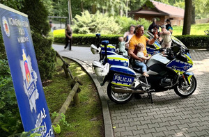w krakowskim zoo mężczyzna pozuje z dzieckiem przy motocyklu do pamiątkowej fotografii