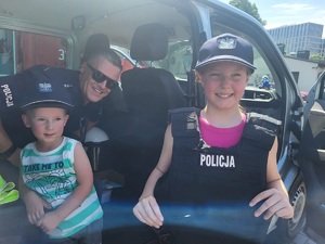 policjant i dzieci siedzące w radiowozie