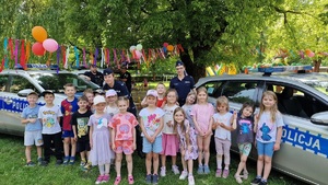 przy radiowozach policjantki z dziećmi pozują do wspólnej fotografii