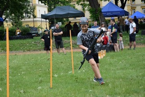 dziecko w hełmie i z karabinem w ręku pokonuje slalom