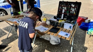 dziecko w koszulce z napisem policja przy stoisku z wyposażeniem technika kryminalistyki