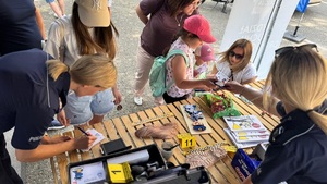 policjanki i uczestnicy pikniku przy stoisku profilaktycznym