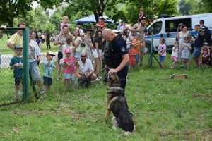 uczestnicy pikniku podziwiają pokaz policyjnego przewodnika i jego psa