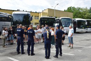 uczniowie oraz policjanci stojący przy autokarze na parkingu Szkoły Policji w Katowicach