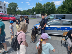 Policyjny przewodnik psa służbowego rozmawia z uczestnikami pikniku