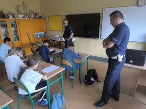 Policjanci pilnują dzieci zdający test na kartę rowerową SP 141
