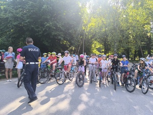 Policjant rozmawia z grupą dzieci przystępujących do egzaminu na kartę rowerową SP 52