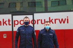 policjanci po oddaniu krwi stoją przed autobusem