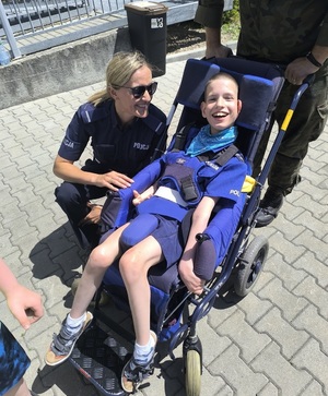 policjantka pozuje do zdjęcia z chłopcem uczestniczącym w festynie
