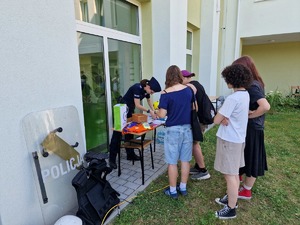 Mlodzież głaszcząca policyjnego psa