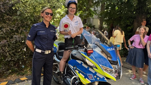 Dziewczynka na policyjnym motocyklu obok policjantka