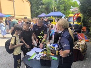 Policjantka rozmawia z osobami przy policyjnym stoisku