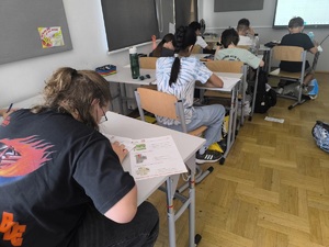 uczniowie zdający egzamin teoretyczny w sali lekcyjnej