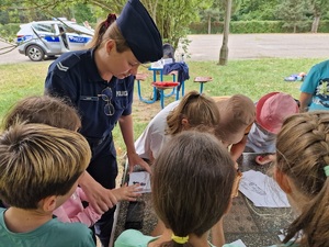 policjantka pomaga odbić odcisk dłoni na pamiątkowej karcie