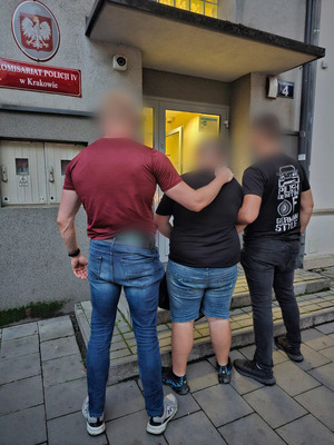 Policjanci operacyjni prowadzą zatrzymanego do komisariatu